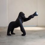 A sculptural gorilla-shaped floor lamp merging artistic expression with functional lighting, crafted from industrial-grade metal and adjustable LED panels for modern interiors.