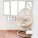 Relax outdoors with a cozy wicker swing chair.
